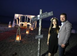 Ürkmez’de Plajda Evlenme Teklifi Organizasyonu 8 İzmir Organizasyon Ürkmez’de Plajda Evlenme Teklifi Organizasyonu; yazı ayrı, kışın ayrı güzelliği vardır. Kentsel gelişmeye karşı dirençli olması en çok sevilen özelliklerden biridir. Mandalinasının ve hatta balığının lezzetini hiç bir yerde bulamadığınız şirin belde. Gümüldür ile Seferihisar arasına sıkışmış az kişinin bildiği sığınılası sahil kasabasıdır Ürkmezdir. Yunus Bey kız arkadaşı Ebru hanım ile olan beraberliklerini, bir ömür boyu yan yana geçirmek istediğine kanaat getirmişti. Ebru hanımla evlilik yolunda ilerlemek istediğine karar veren Yunus bey, peri masalı gibi akıllardan silinmeyecek bir evlenme teklifi organizasyonu yapmak istiyordu. Böyle bir organizasyon için kolları sıvamış ve internetten araştırarak İzmir Organizasyon şirketini sadece birkaç gün önce bulmuş yani bizimle çalışmaya karar vermişti. Yunus bey ofisimize gelip bizimle görüşme fırsatı yakalayamamış, görüşmelerimizi telefonda gerçekleştirmiştik. Kız arkadaşı ile ikisinin de tam bir deniz aşığı olduğunu söyledi ve Ürkmez lokasyonunun hem kendilerine yakın hem de en favori tatil beldesi olduğunu dile getirdi. Ayrıca öyle bir zamanlama yaptı ki yakın arkadaşlarının düğünü olduğu güne denk getirdi evlenme teklifi organizasyonunu. Dolayısıyla biz de o tarihte, deniz kenarında bir evlenme teklifi organizasyonu yapabileceğimiz bahsettik kendisine. Plajda Evlenme Teklifi Organizasyonu