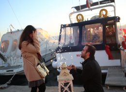 Teknede Evlenme Teklifi Organizasyonu Zeynep Caner2 Copy İzmir Organizasyon Teknede evlenme teklifi organizasyonu ile heyecanlı bir o kadar da romantik bir evlilik teklifi organizasyonuna imza attık. Caner bey kız arkadaşı Zeynep hanım ile olan beraberliklerini evlilik ile taçlandırmaya karar verdikten sonra, Zeynep hanıma unutamayacağı bir evlenme teklifi organizasyonu planlamak istemiş ve bunun için bizimle iletişime geçmiş. Yıllar boyu etkisi sürecek bir sürpriz hazırlamak isteyen Caner beye, daha önce yapmış olduğumuz birbirinden güzel evlenme teklifi organizasyonlarımızın fotoğraf ve video görselleri ile sunumunu yaptık. Caner bey, yapacağı evlenme teklifi organizasyonunun romantik olmasını istediği kadar sıra dışı ve unutulmaz olmasını istediğini dile getirdi. Sunumlarımızı bu ifade doğrultusunda güçlendirdik ve Caner beye deniz tutkusu yüzünden Zeynep hanıma teknede evlenme teklifi yapmak istediğine kanaat getirdi. Evlenme teklifi organizasyonun detaylarını şekillendirmeye başladık. Gün batımında başlayacak olan sürpriz evlenme teklifi organizasyonu şekillendirirken Zeynep hanımın her şeyden bir haber olması gerekliydi. Caner bey için geriye sadece heyecanla teklifin gerçekleşeceği günü beklemek kalmıştı ve biz tüm detaylar için çalışmaya başladık. Teknede Evlenme Teklifi Organizasyonu Zeynep Caner2 Copy İzmir Organizasyon