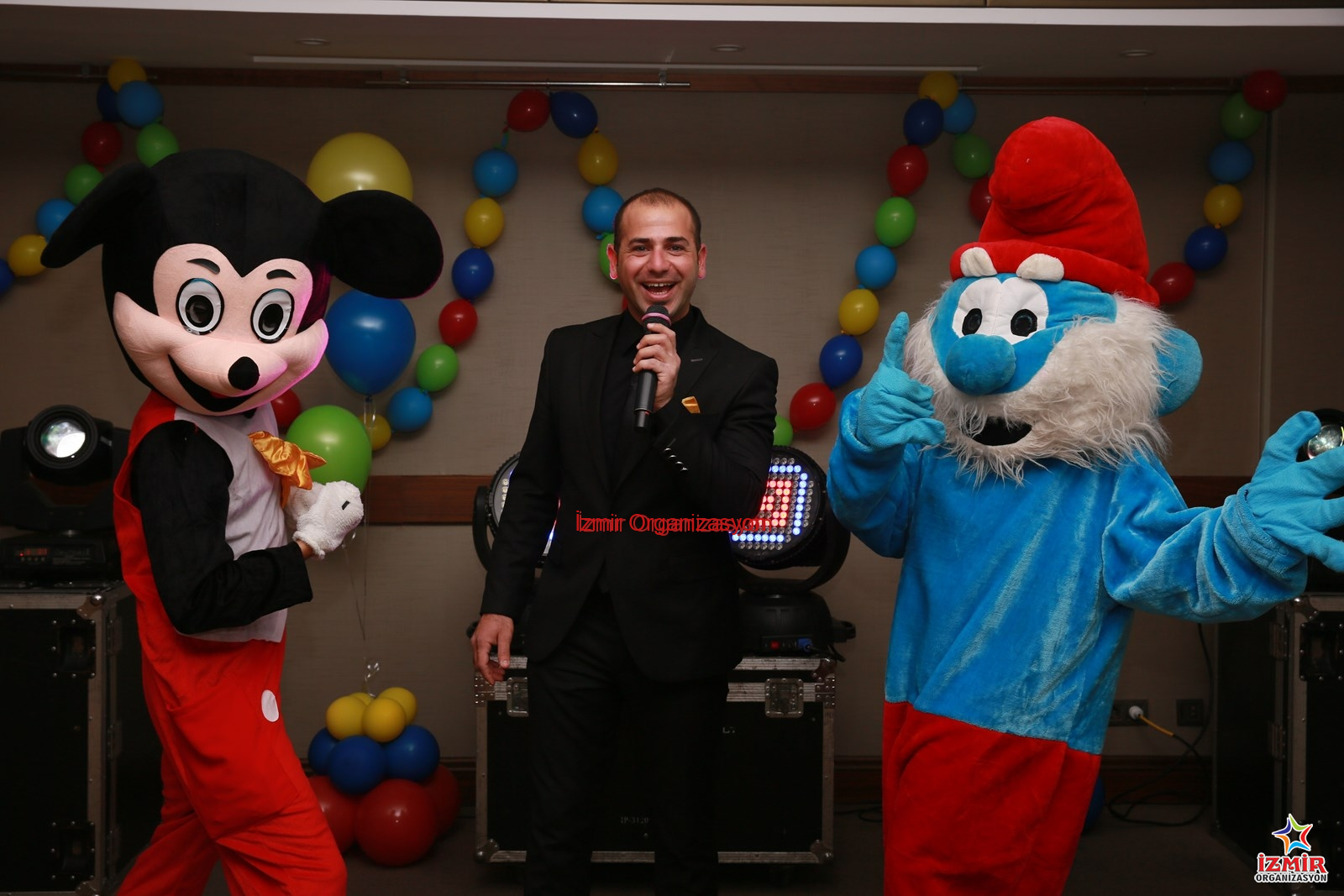 MC ve Sunucu Showman Temini acilis organizasyonlarinda maskot ne yapar 13 İzmir Organizasyon Etkinliğinizin akışını şansa bırakmayın! Açılış, festival, konser, düğün ve kurumsal organizasyonlarınızda; kusursuz diksiyonu, yüksek sahne enerjisi ve etkileyici hitabetiyle kitleleri yöneten profesyonel MC ve Sunucu hizmeti. Organizasyon içeriğine ve çalışacak olan kişiye göre fiyatlar değişiklik gösterecektir. İster resmi bir protokol sunumu, ister eğlence dolu bir Showman performansı... İzmir Organizasyon bünyesindeki deneyimli moderatörlerle etkinliğinizin sesini duyurun. Animasyon Sunucusu ve Çizgi Film Maskotları Kiralama İzmir