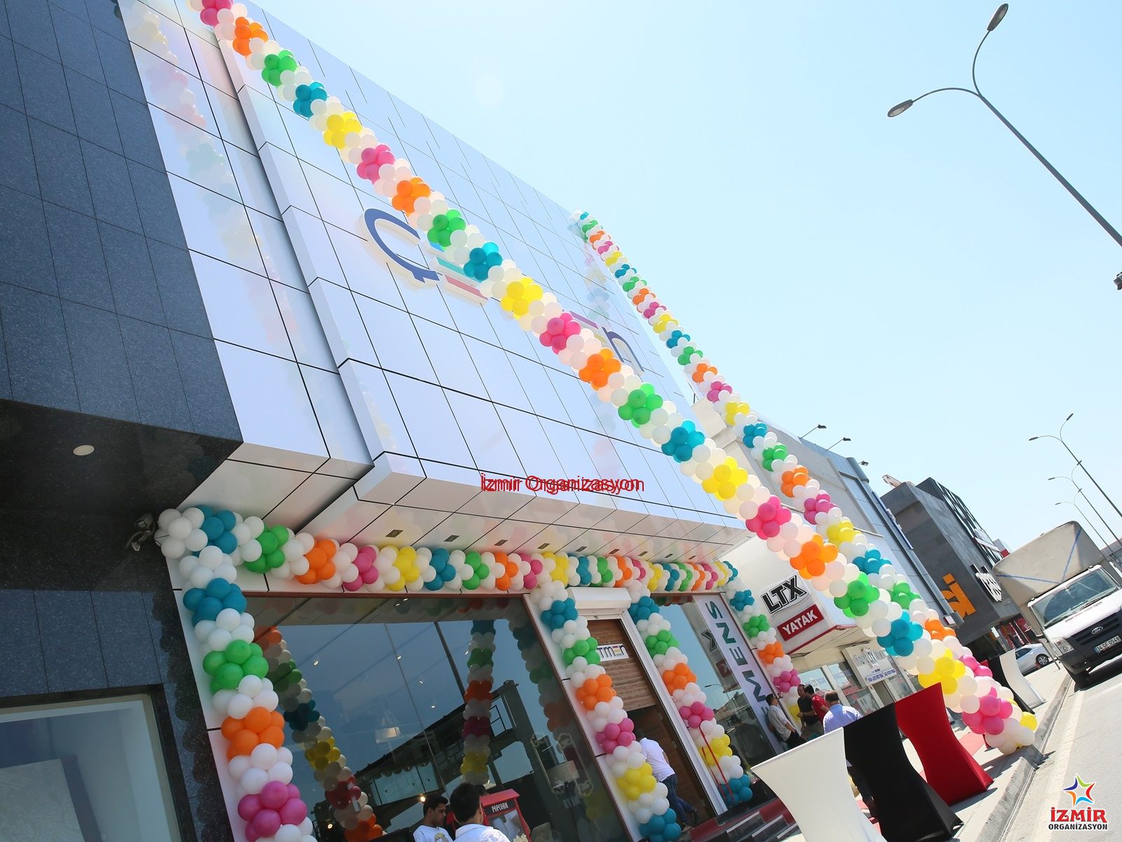 Zincir Balon Süsleme balon standi 8 İzmir Organizasyon İş yerinizin açılışında veya kampanya dönemlerinde tüm gözleri üzerinize çekin! Kurumsal renklerinizle uyumlu, güneşe ve rüzgara dayanıklı profesyonel zincir balon süsleme hizmeti. Kapı takı (ark), sütun balon, bina cephesi veya cadde boyu süslemelerle; markanızın görünürlüğünü İzmir Organizasyon kalitesiyle maksimuma çıkarın. Zincir Balon Süsleme - Görsel 5