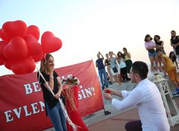 Bostanlı Evlilik Teklifi Organizasyonu bostanli evlilik teklifi organizasyonu 35 İzmir Organizasyon Mucizeye paralel ve rekreatif bir evlilik teklifi organizasyonu yapmak mı istiyorsunuz? Eş adayınızla birlikte masal kıvamında kliplere sürükleneceğiniz, bir evlilik teklifi organizasyonu sizi bekliyor. Kız arkadaşınız için tamamen sürprizlerle dolu olan bu organizasyon sadece sizinler için değil etrafınızda panaromik olarak sizleri hayretler içerisinde izleyen başka gözler de olması da evlilik teklifi organizasyonuna farklılık katıyor. Size uygun olan bir takvimde gün ve saatte bu organizasyonu kusursuzca gerçekleştirebiliyoruz. Gün batımının ufuk çizgisiyle birleştiği anda Bostanlının muhteşem atmosferini kapsayan akşam saatlerini tercih edebilirsiniz. Buna ilave olarak akşam saatlerini de öneriyor olacağız. Uzaktan kumanda ile hareketlenen yer volkanları ile çok enerjik bir görüntü elde edilmesine olanak sağlayacaktır. Evlilik teklifi organizasyonunu konuşlandırdığımız bölge, tüm Karşıyaka kıyı şeridinde denize dik uzanan tek alan üzerinde olmasıdır. Önerilen alan ağaçlıklı yapay bir tepe üzerinden başlayıp denize kadar uzanan bir dizi ahşap platformdan oluşuyor olması. Yüzey formundaki renk ve akıcılık, evlilik teklifi organize ettiğimiz çiftimizi deniz ile daha yakın bir ilişki kurmaları bakımından eşsiz bir manzara oluşturuyor. Dev Pankartla Evlilik Teklifi Organizasyonu