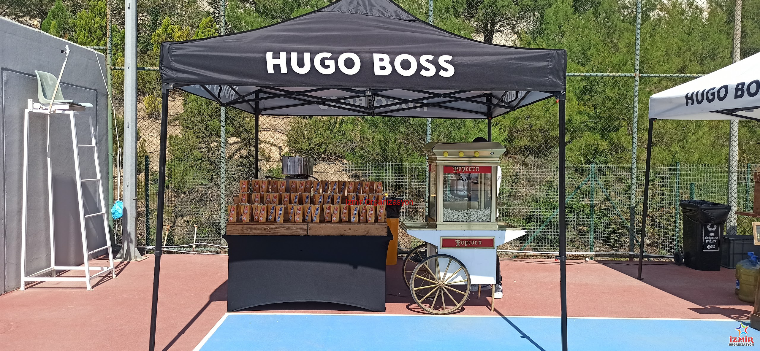 Gazebo Gölgelik Çadır Kiralama gazebo golgelik cadir kiralama 4 İzmir Organizasyon İzmir'deki açık hava etkinliklerinizde misafirlerinizi güneşten ve hafif yağmurdan korumak için 3x3 Metre Beyaz Gazebo Çadır Kiralama hizmetimizden yararlanın. Toplamda 9 m² gölgelik alan sunan bu şık çadırlar, 2.5 metre tepe yüksekliği ile ferah bir kullanım sağlar. Görselde görüldüğü gibi yan yana kurularak uzun koridorlar veya geniş gölgelik adalar oluşturulabilir. Kermesler, bahçe partileri, fuar stantları, piknik organizasyonları ve dış mekan kayıt masaları için idealdir. Beyaz rengiyle her türlü dekorasyona uyum sağlar, temiz ve profesyonel bir görüntü sunar. Kurulum ve toplama işlemi ekibimiz tarafından yapılmaktadır. Stok durumu ve nakliye planlaması için bizimle iletişime geçebilirsiniz. Gazebo Gölgelik Çadır Kiralama - Görsel 7