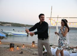 Issız Adada Evlilik Teklifi Organizasyonu issiz adada evlilik teklifi organizasyonu 10 İzmir Organizasyon Issız adada evlilik teklifi organizasyonu; başlıkta bahsetmiş olduğum ne Büyük Ada, ne Gökçe Ada ne de İğneli Ada… Bir insan ve üç obje sorusuna tanıklık etmiş ıssız bir ada. Yanlış yazmıyoruz; burada evlilik teklifini nasıl yapabildiniz sorularına çoğu kez şahit olup, hatta kendimize bile inanmayıp biz bunu nasıl yapabiliriz diye bile sorarken bulduk kendimizi. İzmir Organizasyon olarak yaptık ve de harikalar yarattık. İzmir’e oldukça yakın kilometre taşları olmayan mutlaka bir tekne yardımıyla gidilen bu sessizliğine terk edilen adada yaşam olmamasının sebebi ise çoğu zaman ada koşullarının insan yaşamına uygun özellikleri karşılayamaması olarak gösterir. Yetersiz coğrafi koşullar ya da bitki örtüsü nedeniyle bu adalarda yaşam sürdürmek imkansız. Filmlere, dizilere ve masallara pek çok kez konu olan bu gizemli adalar, günümüzde genellikle bilimsel araştırmalar için kullanılıyor. Ayrıca turizm amacı ile bazı ıssız adalara çeşitli keşif turları da düzenleniyor. Biz de kısa bir keşif yaptık. Çağan Bey bizi aylar önce telefonda aramış yazlıklarının karşısında bulunan çokta küçük olmayan ıssız bir adada, dört senedir birliktelikleri olan kız arkadaşı Çamay Hanıma evlilik teklifi organizasyonu yapmak istediğini belirtmişti. Şampanya Patlatma ve Evlilik Teklifi Organizasyonunun Kutlandığı Anlar