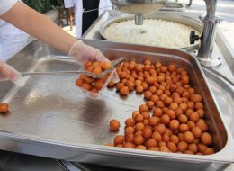 İzmir Lokma - Lokma Standı izmir lokma lokma standi 3 İzmir Organizasyon 'İzmir Lokma', Türk kültürünün, özellikle de İzmir kentinin simgelerinden biridir ve o güzel lezzetinin yanında maneviyatı gereği de önemli bir tatlıdır. Mayalanmış hamurun kızartılması ve şerbetlenmesiyle dilde muazzam bir tat bırakır. İzmir kültüründe ve mutfağında büyük öneme sahip olan İzmir lokması yıllar boyunca, insanların acılarını, hüzünlerini, mutluluklarını, sevinçlerini ve heyecanlarını tanıdığı ya da tanımadığı kişilerle paylaşmalarıyla bilinir. Kimi zaman büyük bir özveriyle satın alınan bir ev, kimi zaman büyük uğraş sonucu kazanılan bir sınav, zaman zaman da çok sevilen yakınların kaybı neticesinde, iş yerleri, sokaklar ve camiler önünde bu özel tatlının ikram edildiğini görürüz. İnanç gereği duaların, dileklerin de paylaşıldığı ve hayırseverliğin de dostlara aşılandığı düşünülür. Bizler de paylaşımın önemli bir olgu olduğunu düşünerek, son teknoloji lokma makineleriyle, hijyen kurallarına uygun olarak, birinci sınıf kaliteli ürünlerimizle sizler için 'lokma standı kiralama' hizmeti sunuyoruz. Açılış Organizasyonu Lokma Standı Kiralama İzmir