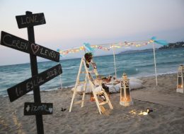 Kumsalda Minder Dekor İle Evlilik Teklifi Organizasyonu Paketi kumsalda minder dekor ile evlilik teklifi organizasyonu paketi 12 İzmir Organizasyon Kumsalda minder dekor ile evlilik teklifi organizasyonu paketi; ister bahçede, ister terasta, isterse de şöminenin önünde yere atılmış minderlerin üzerine uzanıp keyif yapmaya ne dersiniz? Bu keyfin içinde bir de hayal ettiğiniz evlenme teklifi organizasyonu varsa. Rahatına düşkün ancak bir o kadar romantik tasarlanan bu dekorda sevdiğiniz bayandan beklediğiniz “Evet “cevabını alabilirsiniz. Büyük, küçük yer minderlerini sadece kapalı alanlarda değil alanlarda, açık alanlarda da liderliğini koruyan ilk dekorlar arasında yer alır. Kumsalda minder dekor ile evlilik teklifi organizasyonu paketi modern bir tarza uygun olarak döşenmiş, sade ve pastel tonların hâkim olduğu, doğal ketenlerin kullanıldığı minderler sizin için ve kız arkadaşınız için oldukça güzel sinerji yaratabilecek bir ortam hazırlar. Geçmişte sedir olarak bildiğimiz minderler artık özel günlerimizde bize romantik bir fark oluşturarak ayrı bir bakış açısı yaratır. Saman rafyalarla, yavru ağzı tonların denizin mavi tonlarıyla birleştiği ekru kumun saf renginin bütünleştiği bir alanda sürpriz evlilik teklifi organizasyonunu farklı şekillerde gerçekleştirebilirsiniz. Dahası kız arkadaşınızı sahilde yürüyüşe davet edip çıplak ayakla bulunduğumuz konuma getirebilirsiniz. Hayallerinizi süslemek bize, hayal kurmak ise size kalmış… Çeşme Kumsalda Evlilik Teklifi Organizasyonu