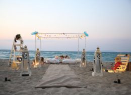 Kumsalda Minder Dekor İle Evlilik Teklifi Organizasyonu Paketi kumsalda minder dekor ile evlilik teklifi organizasyonu paketi 13 İzmir Organizasyon Kumsalda minder dekor ile evlilik teklifi organizasyonu paketi; ister bahçede, ister terasta, isterse de şöminenin önünde yere atılmış minderlerin üzerine uzanıp keyif yapmaya ne dersiniz? Bu keyfin içinde bir de hayal ettiğiniz evlenme teklifi organizasyonu varsa. Rahatına düşkün ancak bir o kadar romantik tasarlanan bu dekorda sevdiğiniz bayandan beklediğiniz “Evet “cevabını alabilirsiniz. Büyük, küçük yer minderlerini sadece kapalı alanlarda değil alanlarda, açık alanlarda da liderliğini koruyan ilk dekorlar arasında yer alır. Kumsalda minder dekor ile evlilik teklifi organizasyonu paketi modern bir tarza uygun olarak döşenmiş, sade ve pastel tonların hâkim olduğu, doğal ketenlerin kullanıldığı minderler sizin için ve kız arkadaşınız için oldukça güzel sinerji yaratabilecek bir ortam hazırlar. Geçmişte sedir olarak bildiğimiz minderler artık özel günlerimizde bize romantik bir fark oluşturarak ayrı bir bakış açısı yaratır. Saman rafyalarla, yavru ağzı tonların denizin mavi tonlarıyla birleştiği ekru kumun saf renginin bütünleştiği bir alanda sürpriz evlilik teklifi organizasyonunu farklı şekillerde gerçekleştirebilirsiniz. Dahası kız arkadaşınızı sahilde yürüyüşe davet edip çıplak ayakla bulunduğumuz konuma getirebilirsiniz. Hayallerinizi süslemek bize, hayal kurmak ise size kalmış… İzmir Sahilde Evlilik Teklifi Organizasyonu