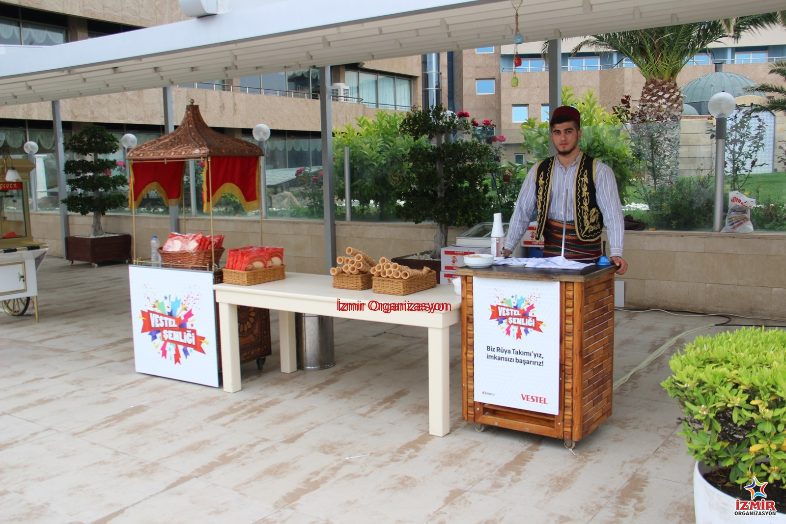 Maraş Dondurmacısı Standı Kiralama & Dondurma İkramı kurumsal motivasyonu artirma 10 İzmir Organizasyon Yaz etkinliklerinin vazgeçilmezi! Geleneksel motiflerle süslü standında, otantik Maraş kıyafeti (cepken, fes) giyen ustamızdan; keçi sütlü, sakızlı ve bıçakla kesilecek kadar sert Hakiki Maraş Dondurması ikramı. Meşhur külah oyunları ve dondurma şovlarıyla misafirlerinizi hem serinleten hem de kahkahaya boğan, sınırsız dağıtımlı profesyonel Maraş Dondurmacısı Kiralama hizmeti. Maraş Dondurmacısı Kiralama İzmir Kurumsal Organizasyonlar