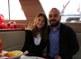 Dostlarla Teknede Evlilik Teklifi Organizasyonu yüzük takma İzmir Organizasyon Teknede Evlilik Teklifi Organizasyonu için Mutluluk Teknesi iş başında. Birbirinden güzel organizasyonlarla adından sıkça söz ettiren firmamızın bugünkü hedefi yine sürprizlerle dolu bir evlilik teklifiydi. Eray bey, Nükte hanımla olan ilişkisinde daha ciddi bir adım atarak, evlilik teklifi yapmaya karar vermiş ve yaptığı araştırmalar sonucu bize İstanbul’dan ulaşmıştı. Eray bey romantik ve kusursuz olduğu kadar sürpriz bir evlilik teklifi yapmak istiyordu. İstanbul’dan İzmir’e geleceği için, kendine bu heyecanlı gününde destek verebilmesi adına dostlarını da bu sürprize dahil etmek niyetindeydi. Ekip arkadaşımız geçmişte yapmış olduğumuz evlilik teklifi organizasyonlarının fotoğraf ve videolarını, Eray beyle internet yoluyla neler yapabileceğimiz konusunda fikir telakisinde bulundu. Kordonda evlilik teklifi, kumsalda evlilik teklifi, helikopterde evlik teklifi, limuzinde evlilik teklifi gibi birçok seçenek sunduk. Arkadaşlarıyla organize edeceği bu evlilik teklifi organizasyonun teknede olmasına karar verdik. Ardından Eray bey ile beraber evlilik teklifi organizasyonunu planladık. Genç çiftimiz tam bir deniz aşığı ve tekne tutkunu olduğu için çiftimiz için kusursuz olan bu evlenme teklifi organizasyonunun detaylarını, organizasyonun günü ve saati kararlaştırıldı. Artık Eray bey için geriye sayım başlamıştı. Nükte hanımı ise göz kamaştırıcı sürprizler beklemekteydi. Teknede atıştırmalık Yüzük